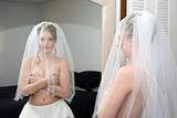 Autumn Bride covering her breast with veil on looking in mirror.