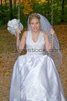 Autumn Bride on swing set in park.