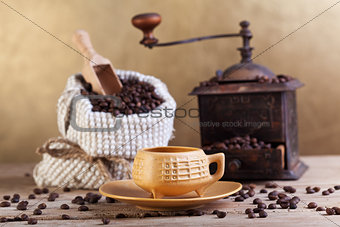 Coffee beans in a bag with grinder and cup
