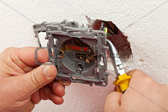 Electrician connecting electric wall fixture to the wires