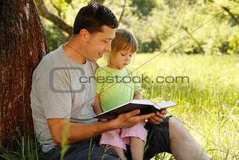 young father with his little daughter reading 