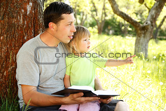 young father with his little daughter reading