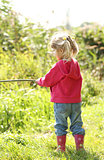 beautiful little girl in nature playing with a stick 