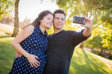 Pregnant Wife and Husband Taking Cell Phone Picture of Themselve