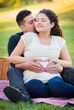 Pregnant Hispanic Couple Making Heart Shape with Hands on Belly