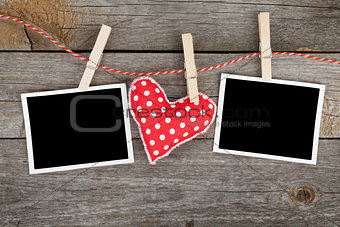 Two blank instant photos and red heart hanging on the clotheslin
