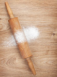 Rolling pin with flour on wooden table