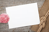 Blank paper card with seashell and ship rope