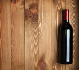 Red wine bottle on wooden table background
