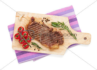 Sirloin steak with rosemary and cherry tomatoes on a cutting boa