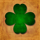 green four-leaved shamrock in old paper background