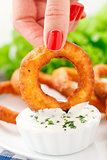 Fingers holding onion ring