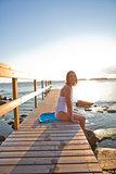 Attractive woman sitting on pier