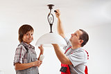 Father and son installing a ceiling lamp