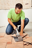 Man cutting ceramic floor tiles