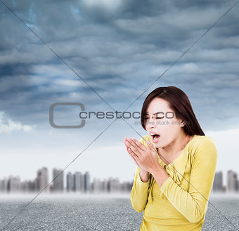 young woman blowing to warm hands up with black clouds