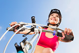 female biker starting to ride with blue sky background