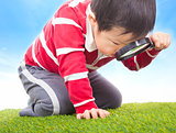 a boy exploring nature with magnifying glass