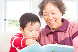 grandmother and grandson are reading story book together