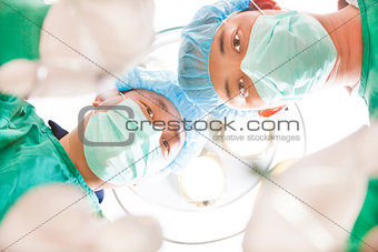 Surgeons and medical assistant working in operating room