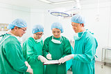 surgeons discussing about something in operating theater