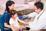 Pediatrician rubbing medication on  little girl arm wound 