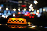 Illuminated taxi cab sign on a city street