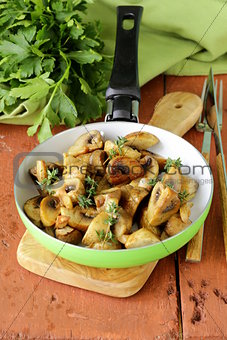fried champignon mushrooms with thyme in a pan