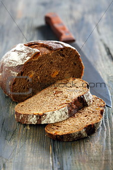 Rye bread with dried apricots and a knife.
