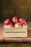 fresh ripe organic red apples in a wooden box