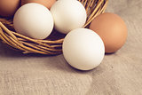 chicken eggs in basket on burlap