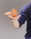 female teen hand presenting egg