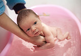 Mom bathing cute baby boy