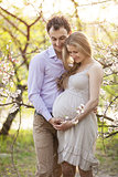 Young pregnant couple outdoors in spring