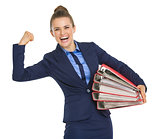 Smiling business woman with stack of folders showing biceps