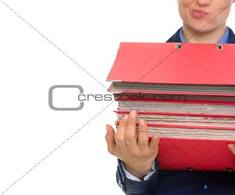 Closeup on doubting business woman with stack of folders