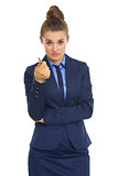 Business woman pointing in camera with pen