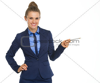 Smiling business woman pointing on copy space with pen