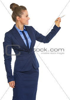 Happy business woman writing in air with pen