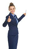 Smiling business woman pointing on copy space with pen and showi