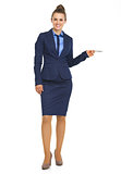 Full length portrait of business woman pointing on copy space wi