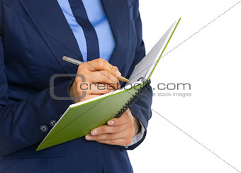 Closeup on business woman writing in notepad