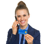 Portrait of smiling business woman with credit card talking cell