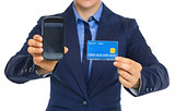 Closeup on business woman showing phone and credit card