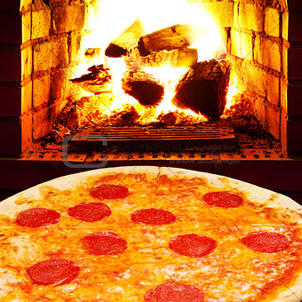 pizza with salami and open fire in stove
