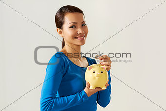 asian girl showing piggybank and euro coin