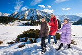 Family (mother with two children) take a walk on winter mountain