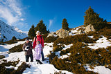 Family (mother with two children) take a walk on winter mountain