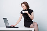 sitting on the table an girl with a laptop and a cup of coffee
