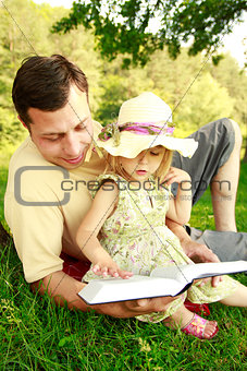 young father with his little daughter reading 